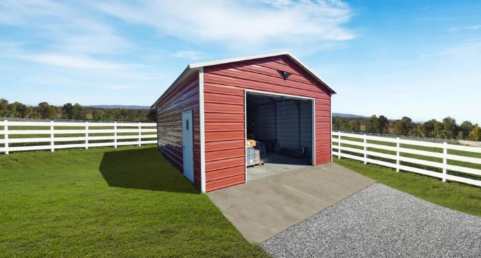 A red shed with a white fence in a field.