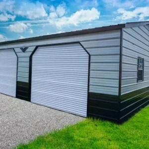 A 24X30X9 Vertical Roof Metal Garage with two doors and a grassy field. This spacious 24X30X9 structure features a durable metal construction ensuring long-lasting durability. Equipped with two convenient doors,