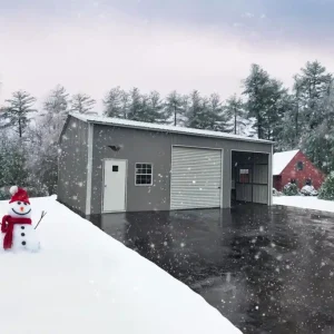 A 28X35X12 Vertical Roof Metal Garage stands vertically in front of a metal garage roof covered in snow.