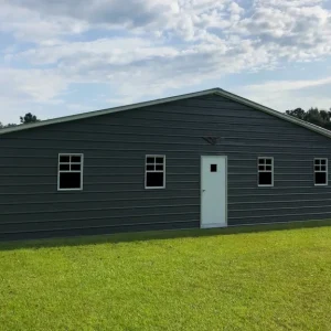 A gray 30X20X8 Vertical Roof Metal Garage sitting on a grassy field.