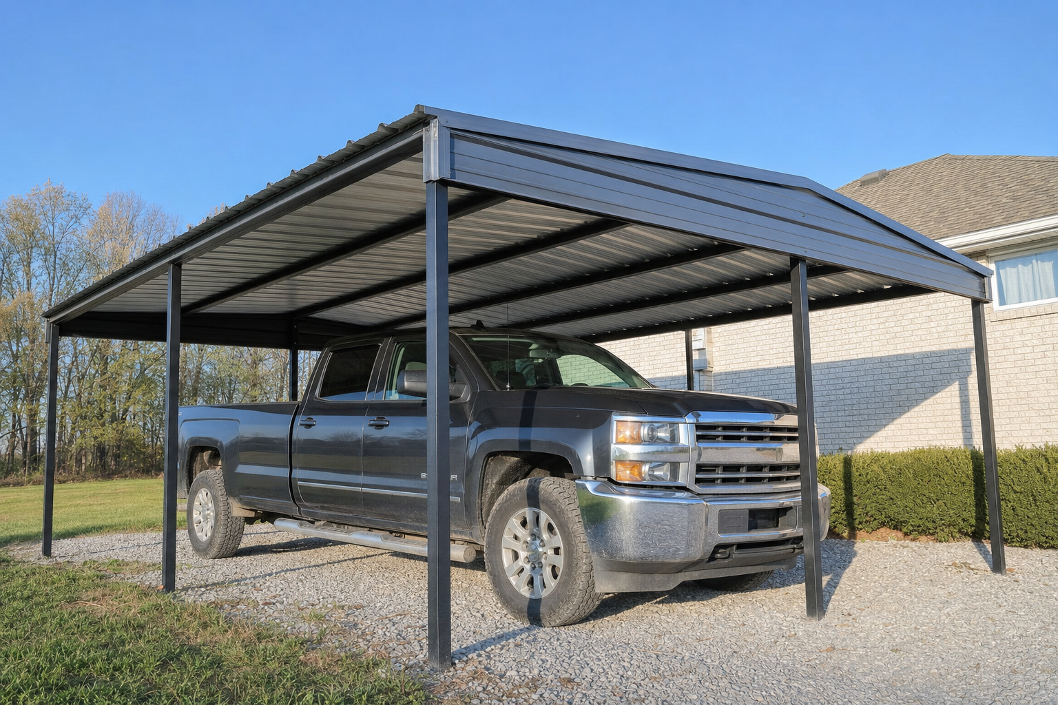 Black pickup truck parked under metal carport at home