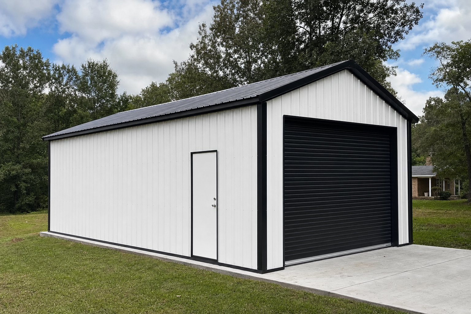 White metal garage building with black trim and roll-up door