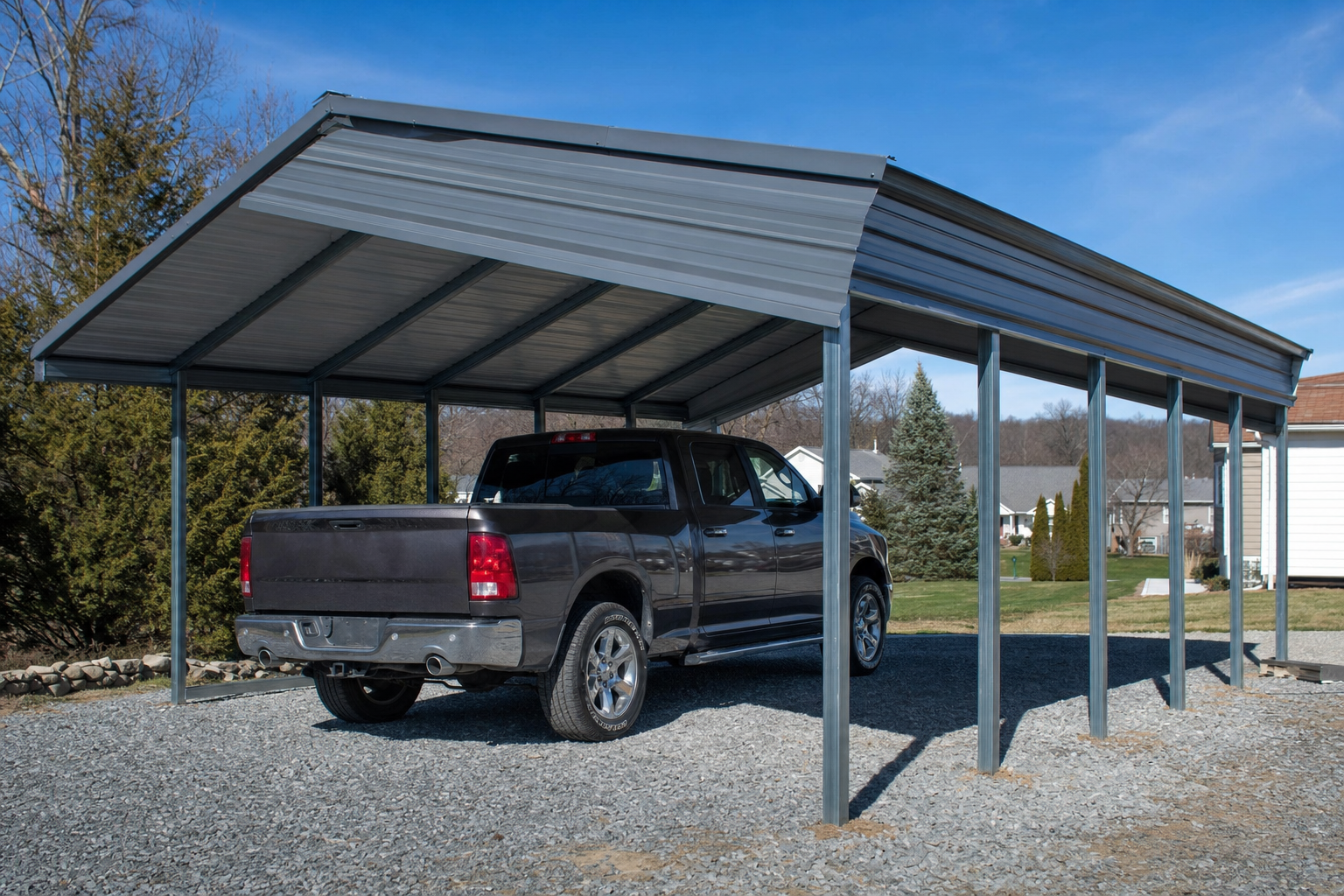 Gray pickup truck parked under metal carport on gravel driveway