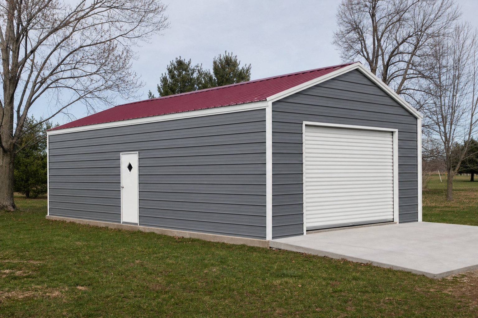 Gray metal garage building with red roof and white roll-up door