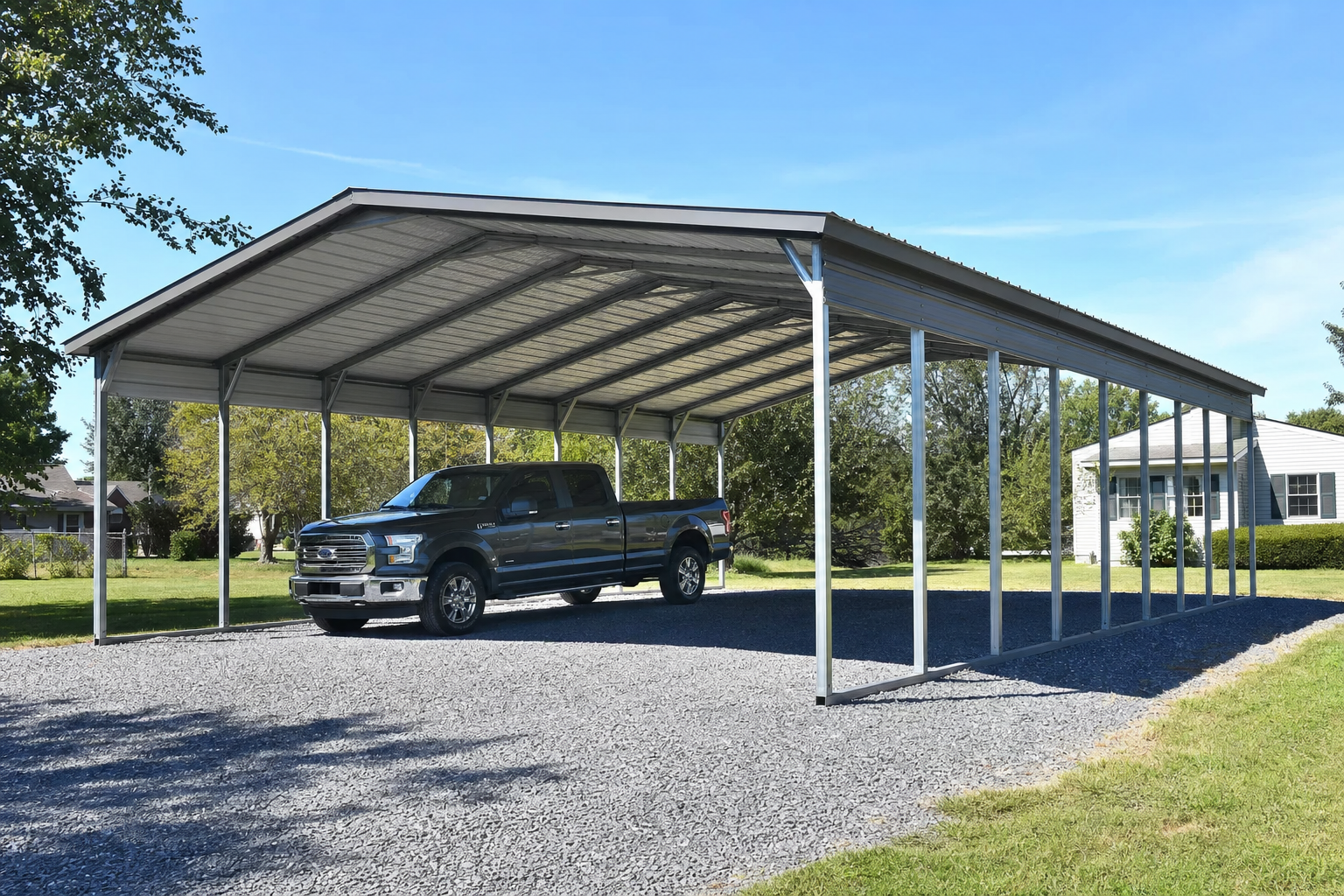 Gray pickup truck parked under large metal carport structure