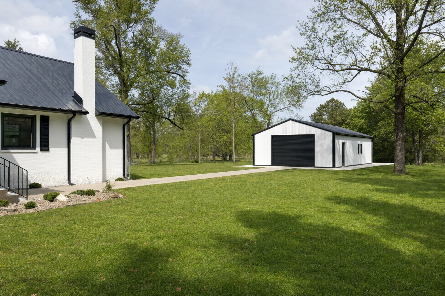 Modern white farmhouse with detached garage on green lawn