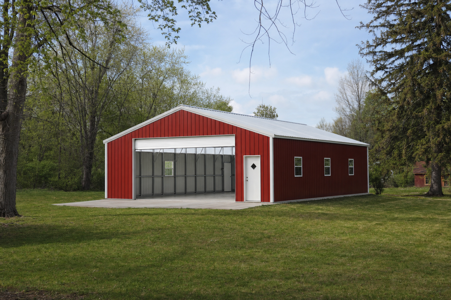 Red metal pole barn with open garage door on green lawn